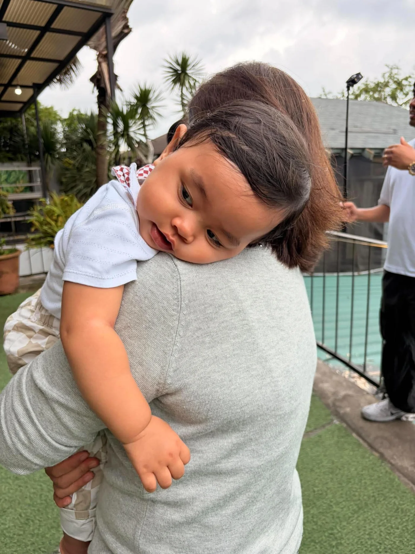 Kensho resting on a shoulder during a cuddle outdoors