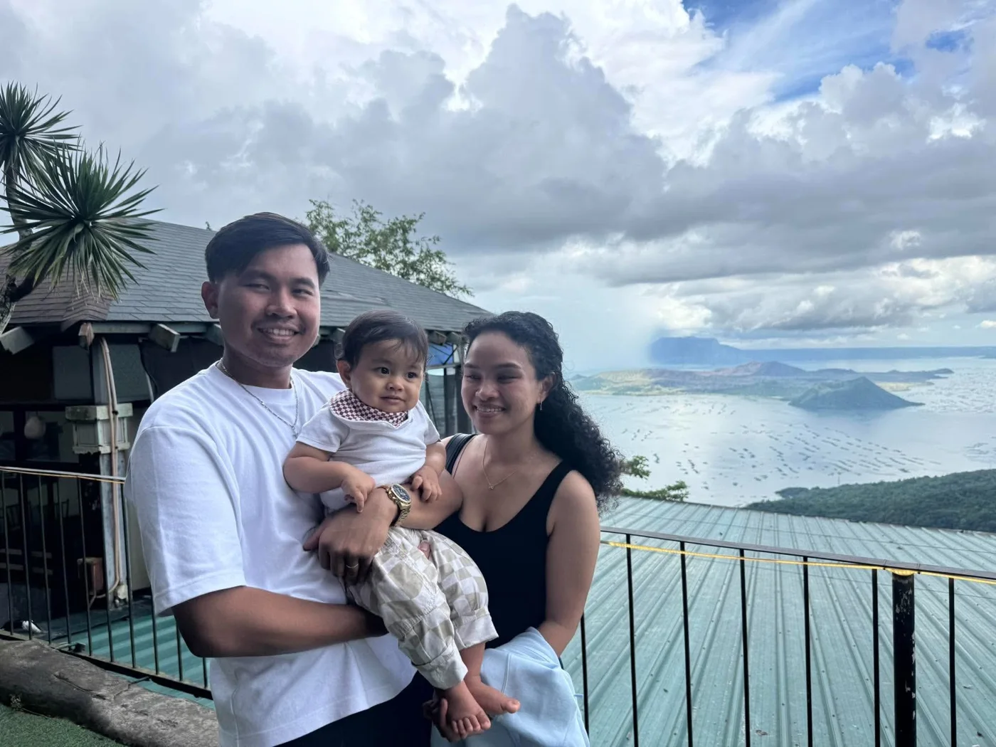 The family standing close together beside the water